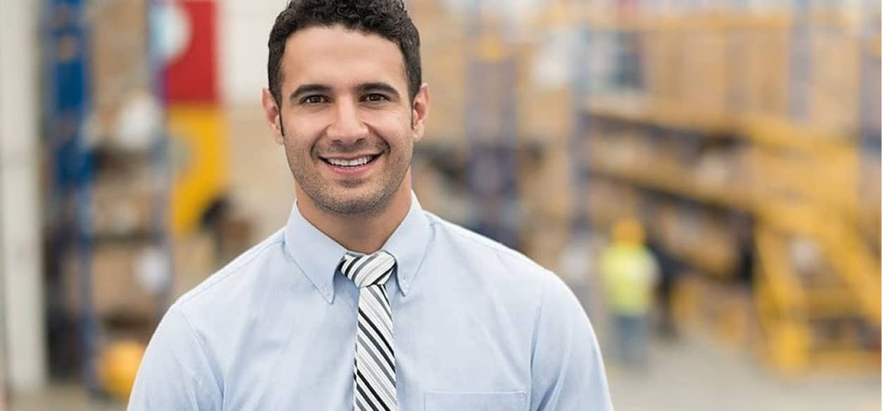 Man in suit standing in a warehouse