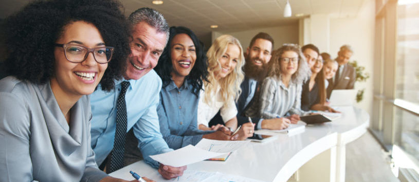 Cheerful multiracial colleagues looking at camera in office