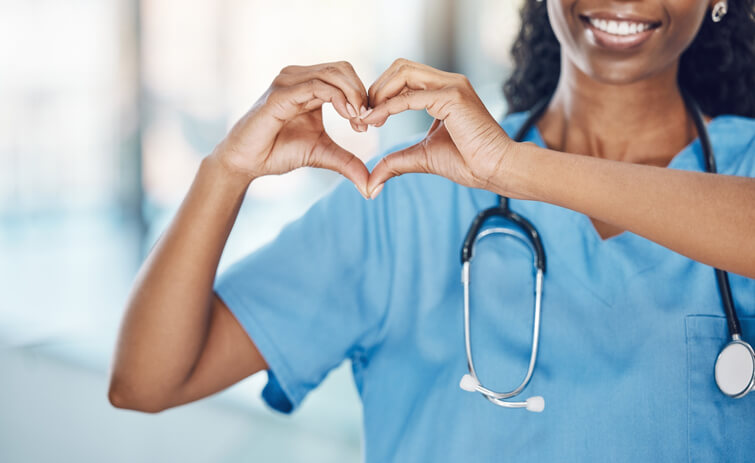 A practical nurse training graduate making a heart shape with her hands, indicating love for oneself, body, and soul.