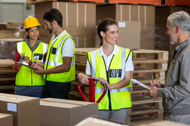 A logistics coordinator and other logistics workers preparing a shipment after earning an international trade diploma