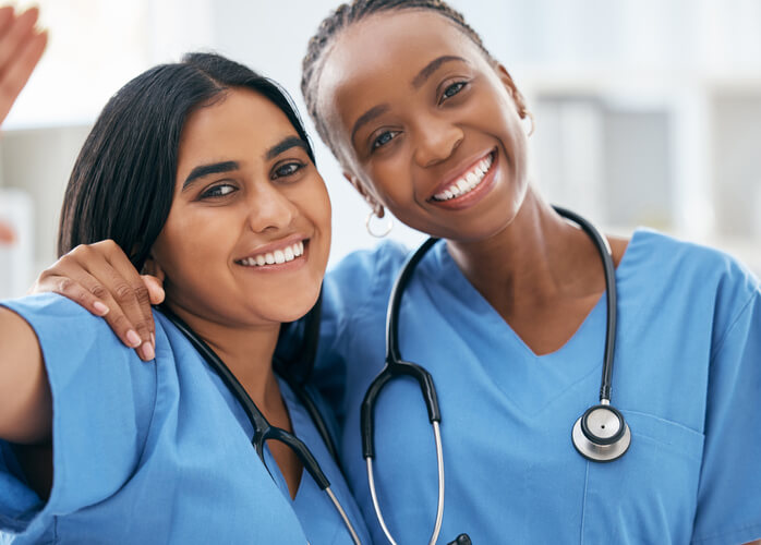 Two practical female nurses smiling in a hospital after their practical nurse training