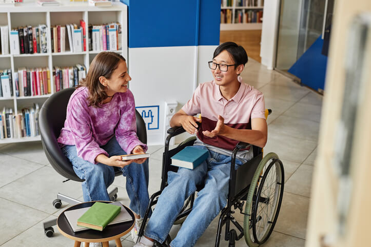 Student in community support worker training helping a disabled teenager