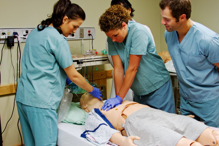 practical nurse training students undergoing a CPR instruction class