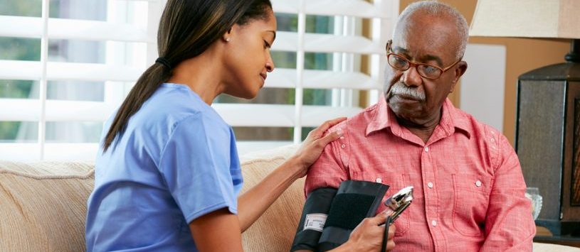 Social Service Worker applying a blood pressure device on a client.