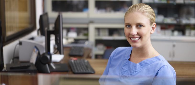 Healthcare administration professional sitting behind a desk.