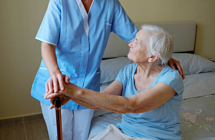 A practical nurse training grad speaking with an elderly patient
