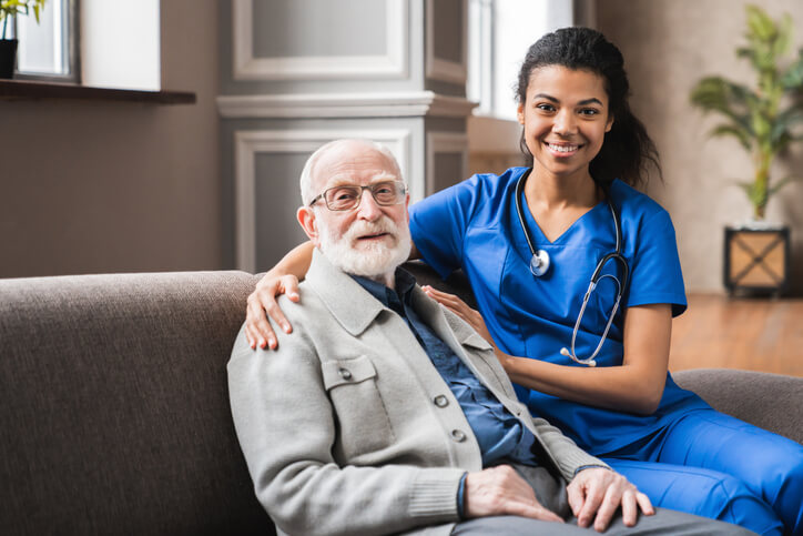 A healthcare assistant training grad posing with an elderly client