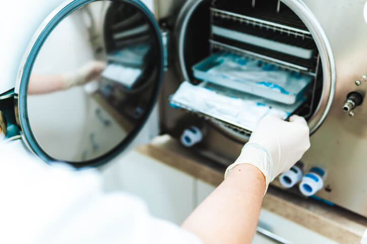 A dental assistant training grad sterilizing instruments