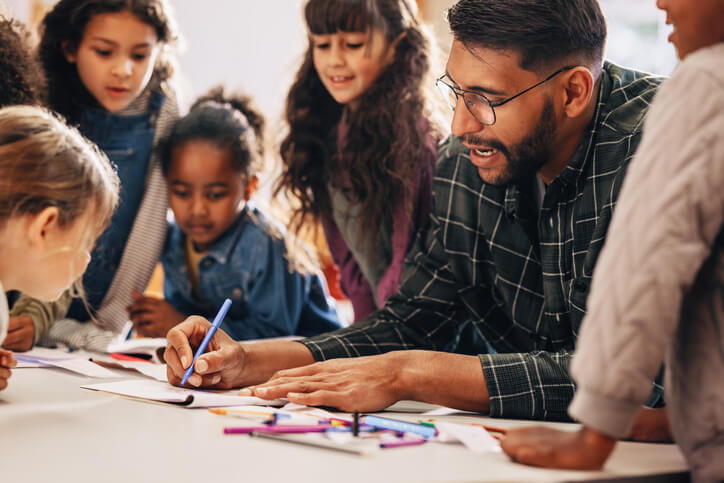 An education assistant training grad helping students with projects