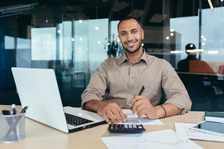 A business finance management training grad sitting at a desk