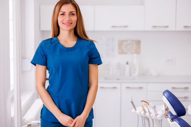 A dental assistant training grad posing in a dental clinic