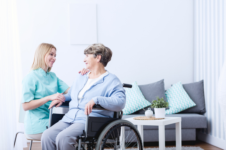 A friendly female healthcare assistant interacting with a female patient after her healthcare assistant training