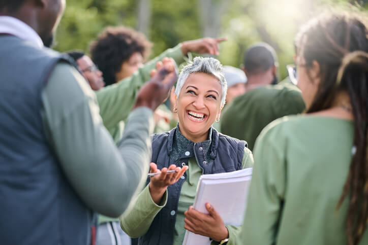 A smiling female community support worker interacting with a group of happy clients