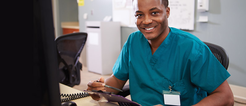 Healthcare Administration professional sitting behind a reception desk.