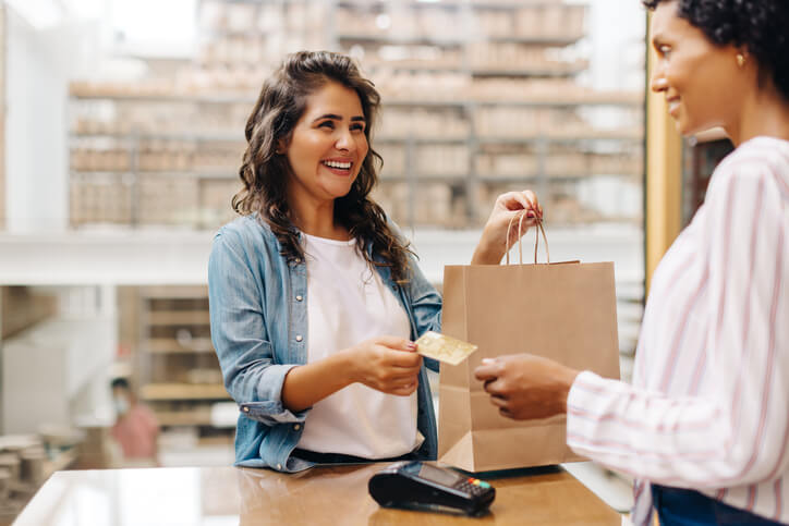 A business office management training grad making a sale at the cash register