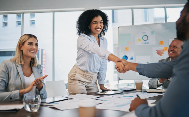 A business office management training grad shaking hands with new clients