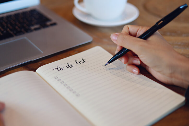 A female student ticking off items on a to-do list during medical office administration training