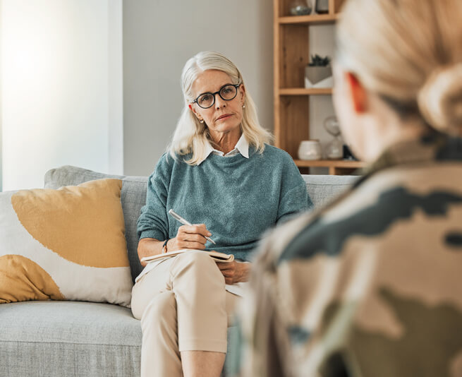 An experienced mental health professional talking to a female client after completing her mental health training