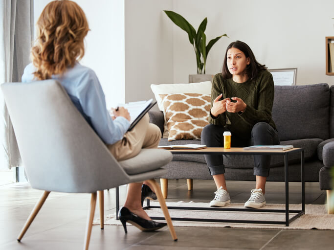 A mental health professional confidently guiding a client through a therapy session after completing her mental health training