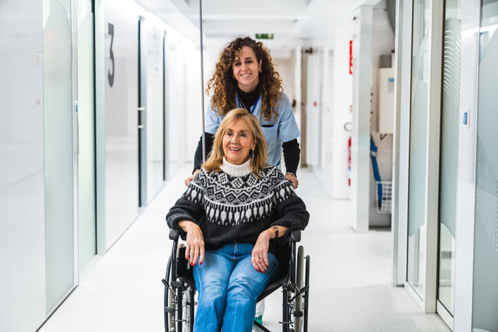 A health care assistant helping a senior in a wheelchair