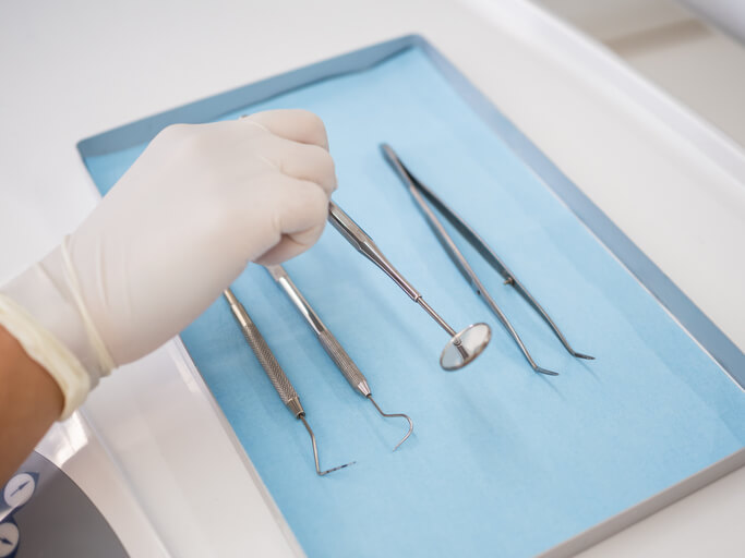 A dental assistant preparing tools at a clinic