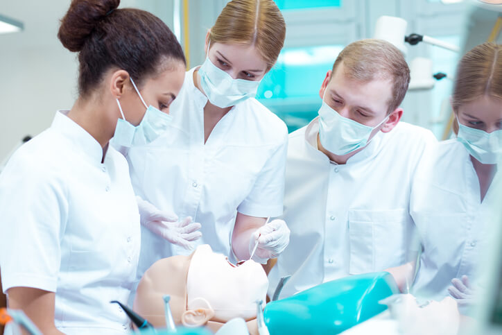 A group of students learning dental procedures in a training lab