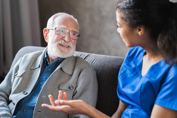 A practical nurse providing support to a senior patient
