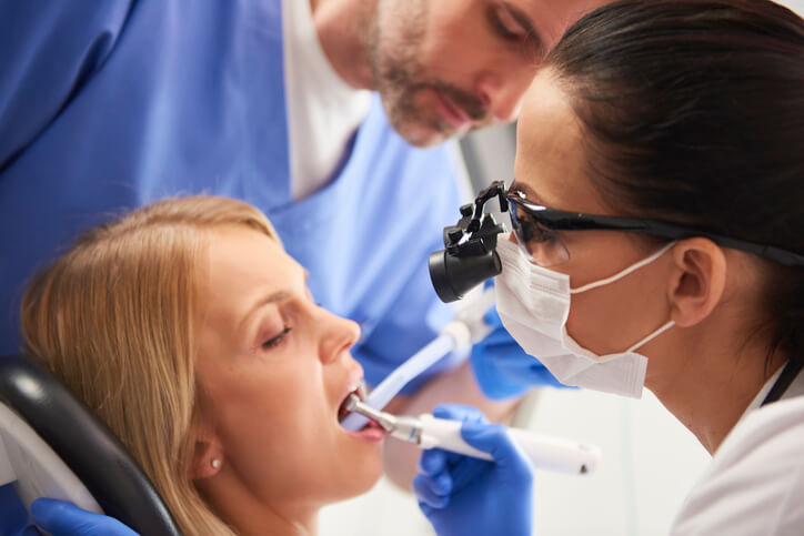 A graduate of a dental assistant diploma program assisting a dentist