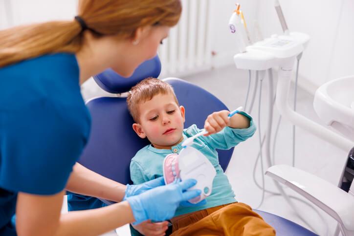 A dental assistant diploma student practicing chairside procedures in a dental assistant training lab