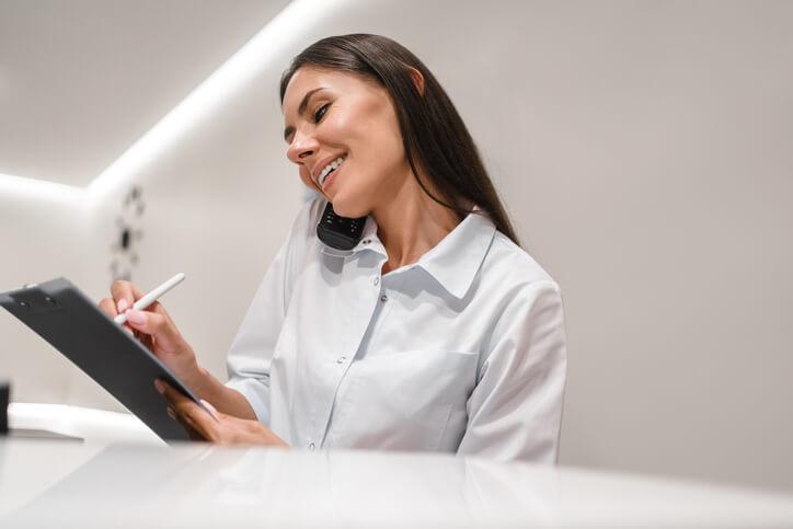 A dental reception course graduate managing records and calls