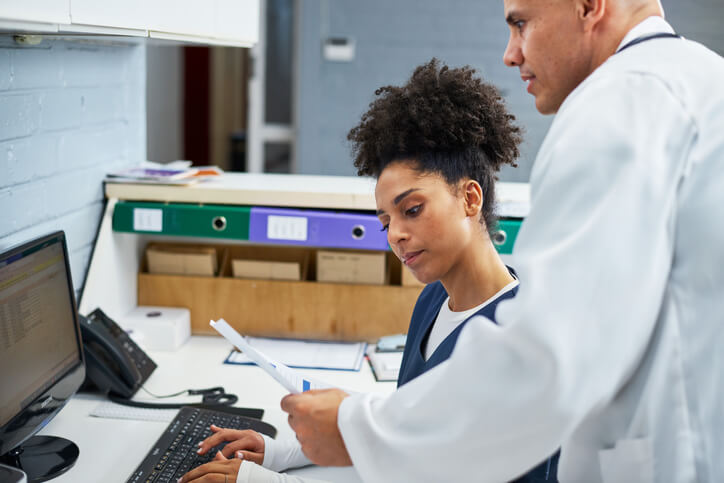 A medical office manager speaking with clinical staff in a healthcare setting