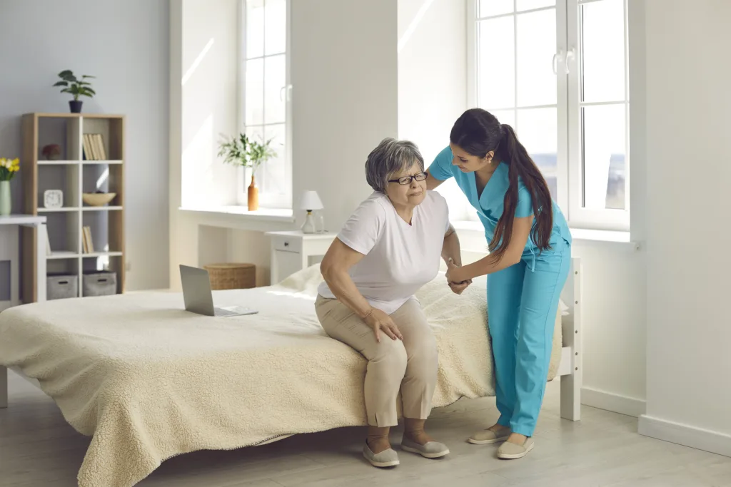 Health care assistant supporting a patient with daily care