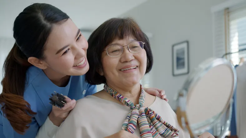 A home care assistant assisting a client with daily living activities
