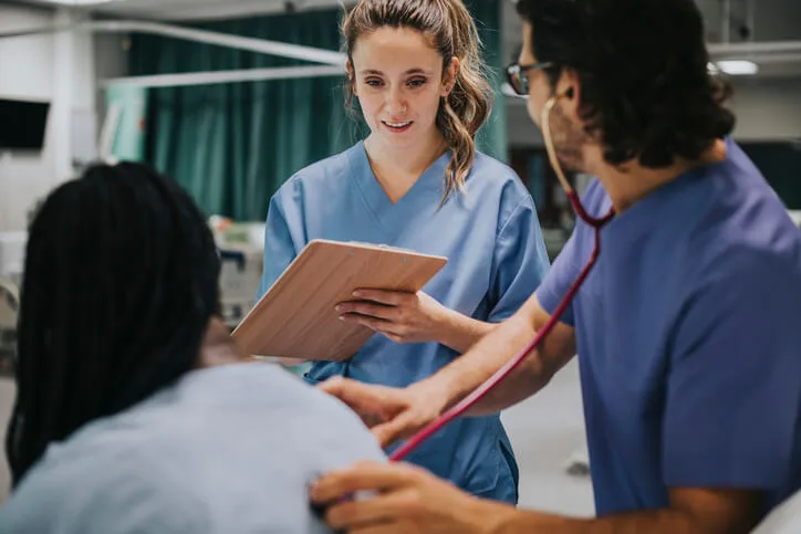 nursing instructor guiding a student during clinical training
