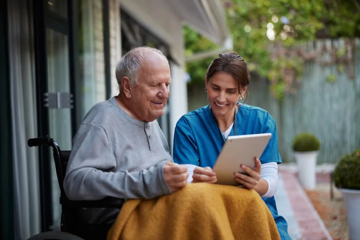 A healthcare worker assisting a senior in a care facility