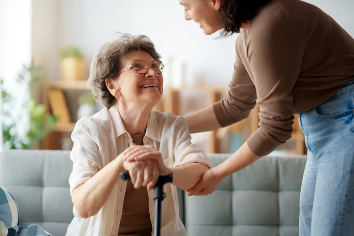A healthcare assistant speaking with a patient during care