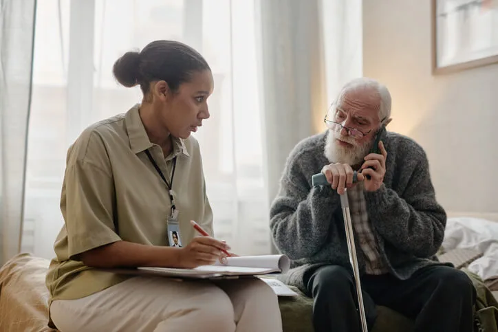 A social service worker in BC speaking with a client in a community support setting