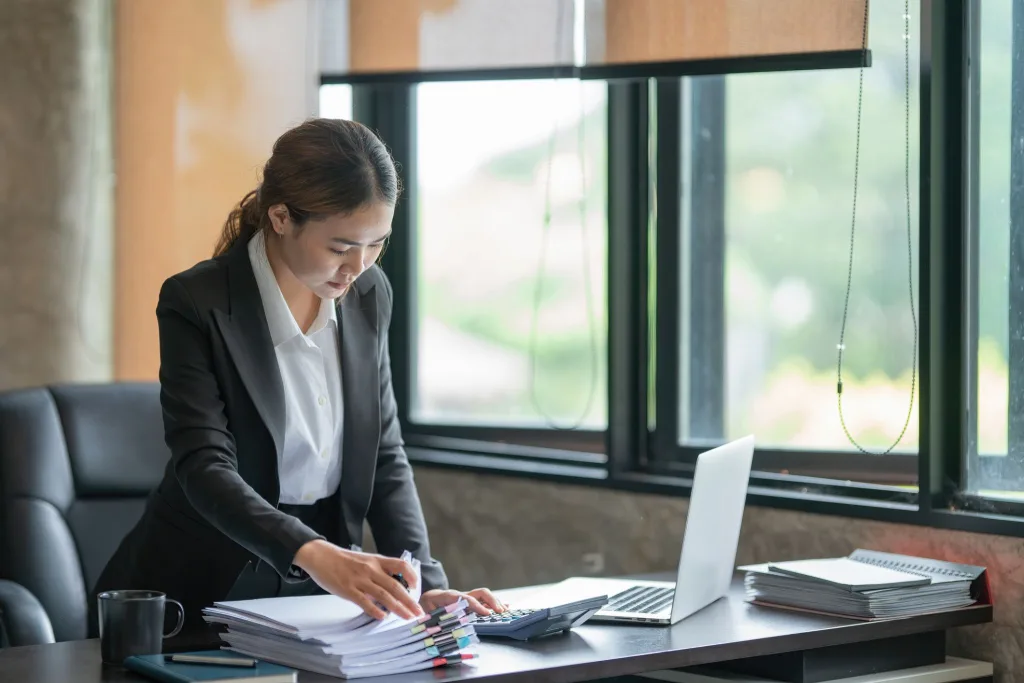 An administrative professional managing bookkeeping and communication tasks in an office environment